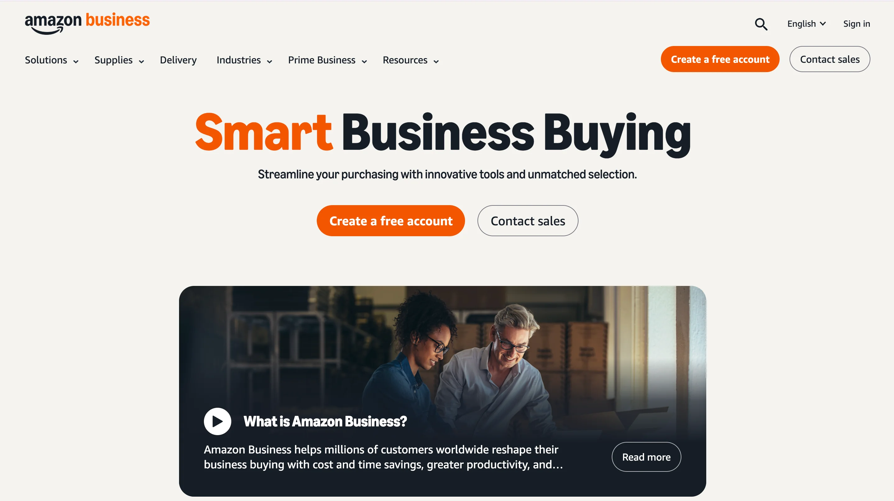 Amazon Business homepage with a cream background, the headline "Smart Business Buying," two call-to-action buttons, and a video thumbnail titled "What is Amazon Business?" showing two people reviewing a laptop.