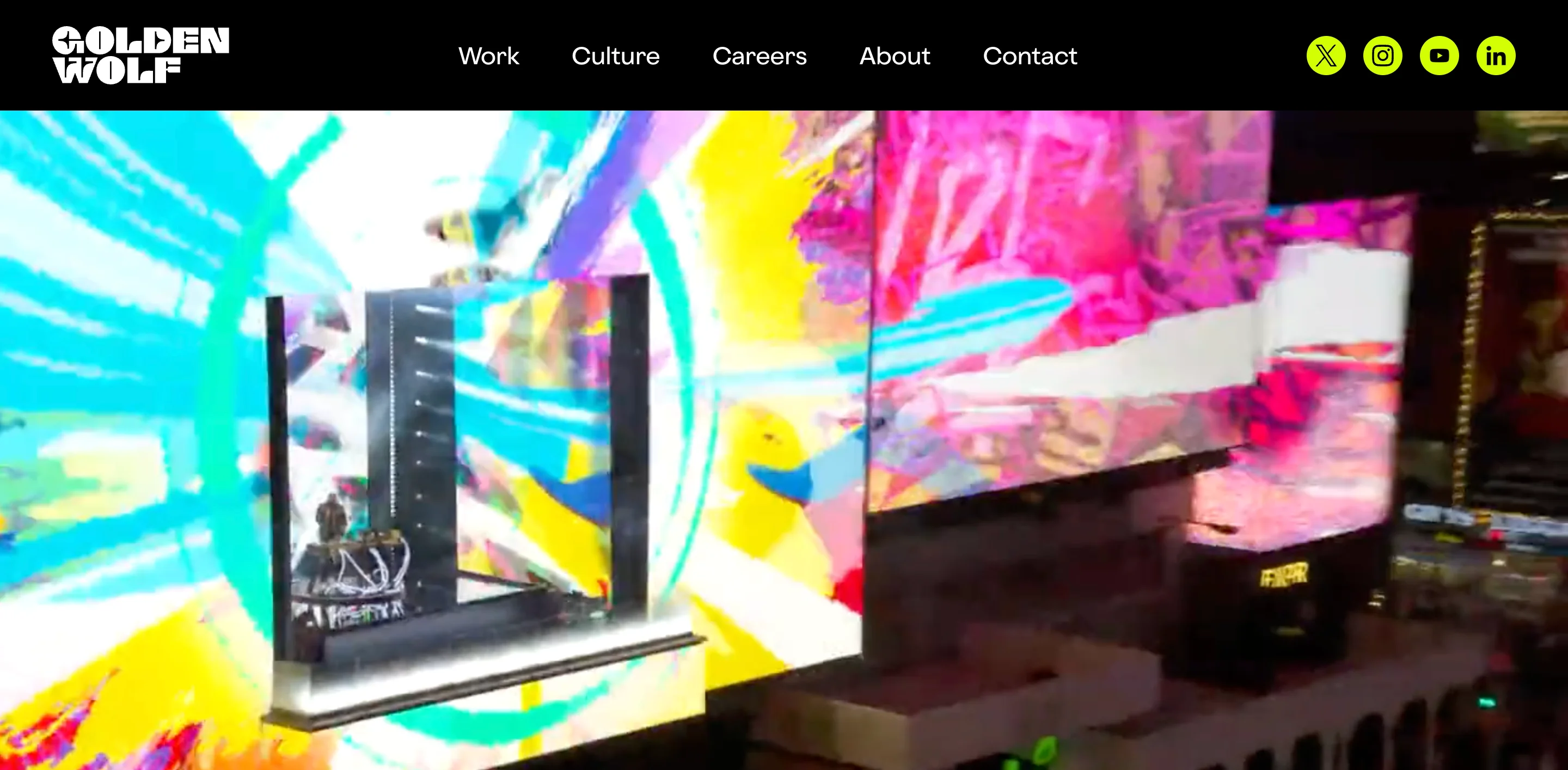 Golden Wolf motion design and animation studio homepage showing a vivid large-scale LED installation with bold multicolor abstract visuals and the Golden Wolf logo in white on a black background