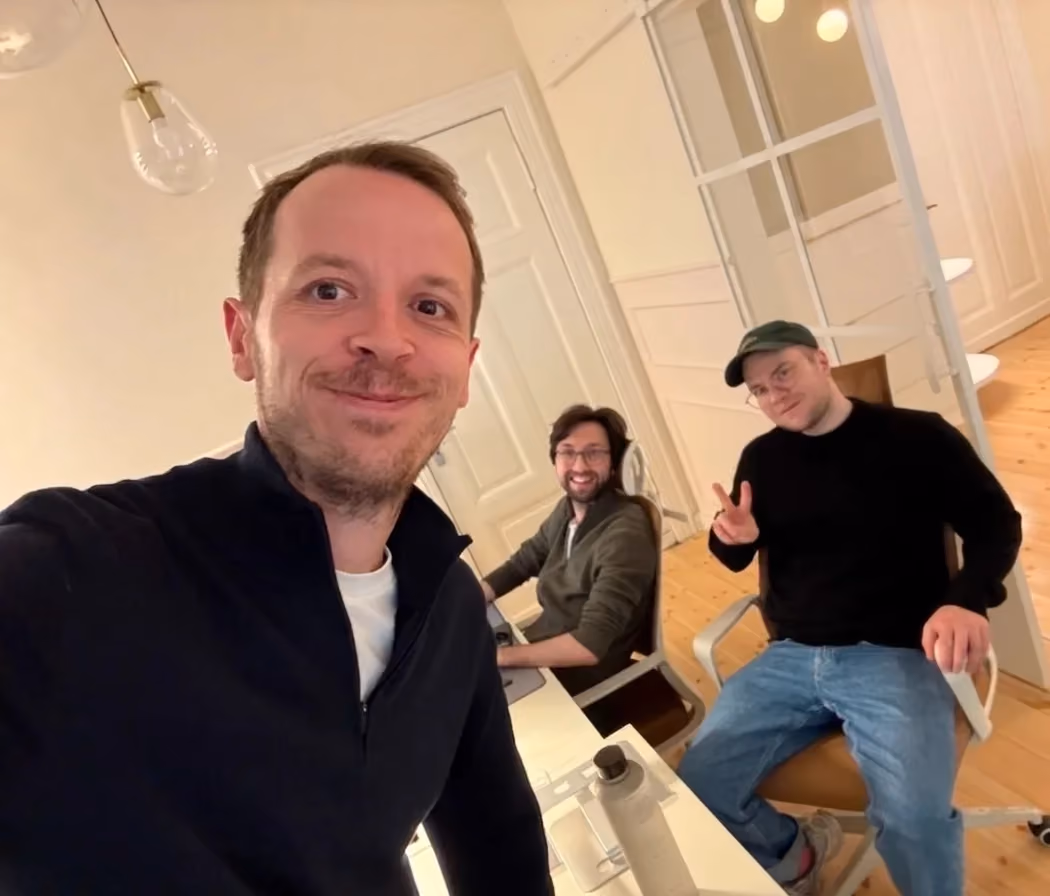 Gabriel Böker and two magier teammates in the office, with a screen in the background showing 844 total applications.