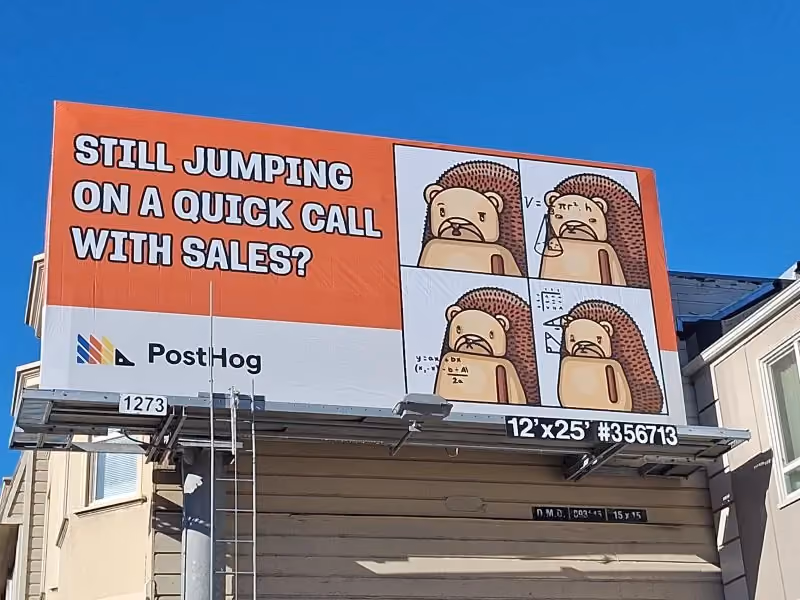An orange and white outdoor billboard for PostHog reading 'Still jumping on a quick call with sales?' next to a four-panel comic of a hedgehog mascot working through a math equation on a whiteboard