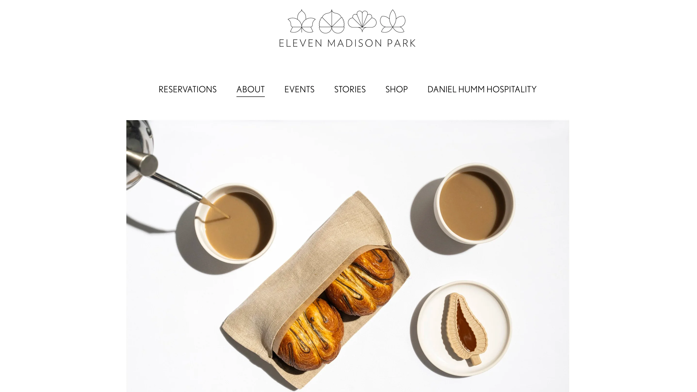 Eleven Madison Park page with the leaf logo, Reservations, About, and Events links, and a coffee and pastries photo