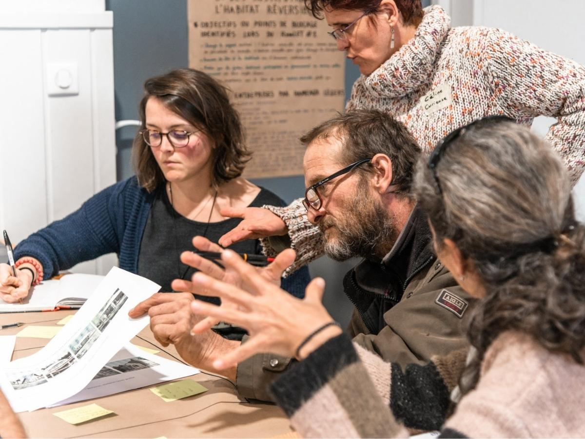 des personnes en discussion autour d'une table et de supports de présentation