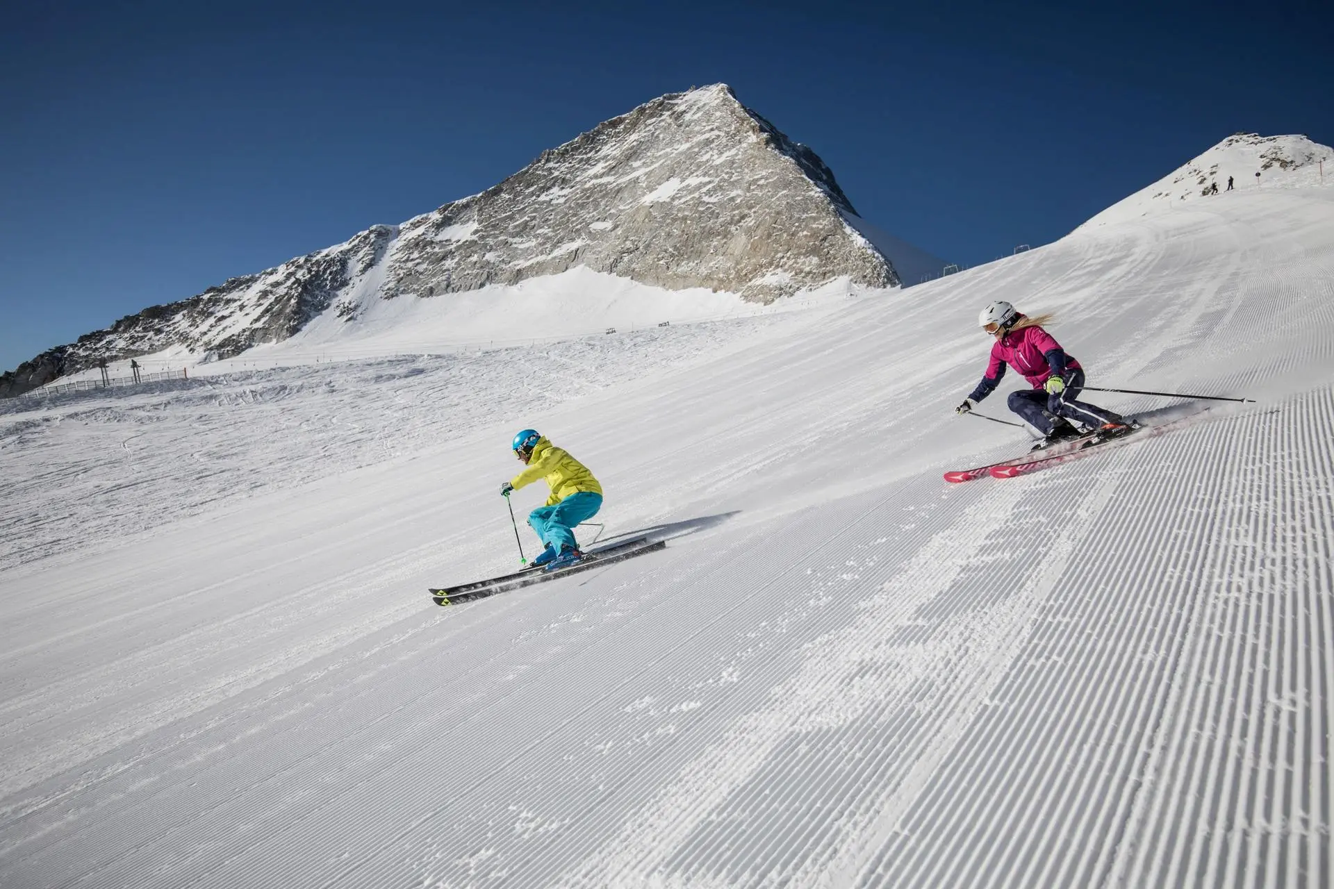 Zwei Skifahrer auf einer frisch präparierten Piste am Hintertuxer Gletscher.