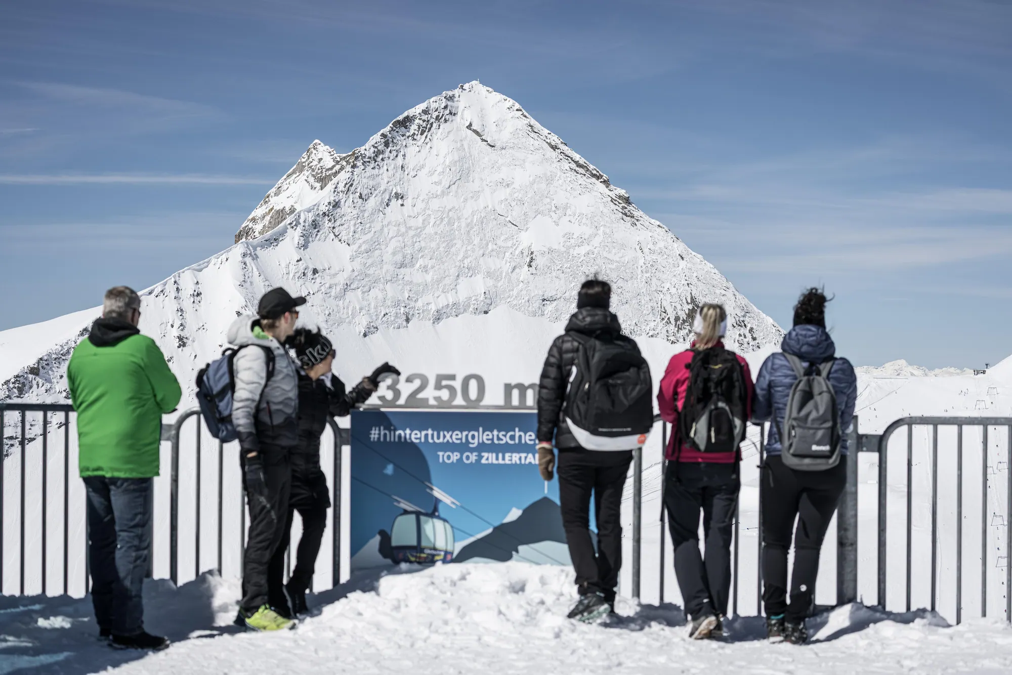 Gäste am Gipfelschild auf 3.250 Metern am Hintertuxer Gletscher.