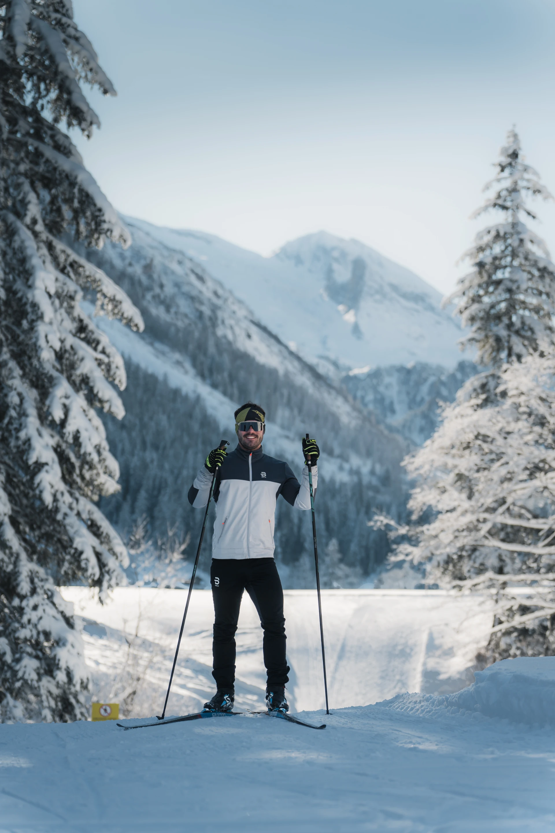 Langläufer auf der Loipe im Tuxertal vor tief verschneitem Wald.
