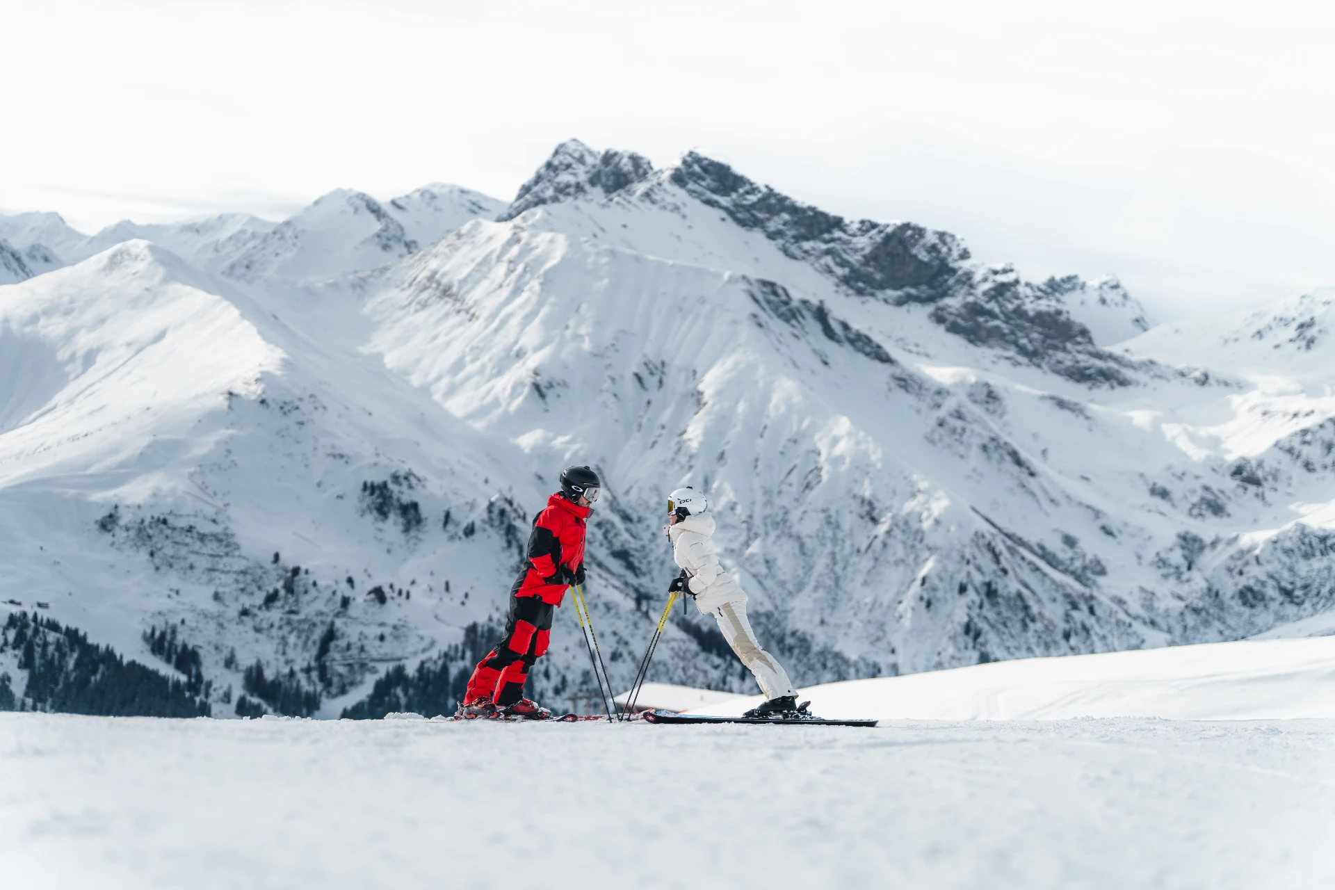 Zwei Skifahrer am Pistenrand vor dem Panorama der Tuxer Alpen.