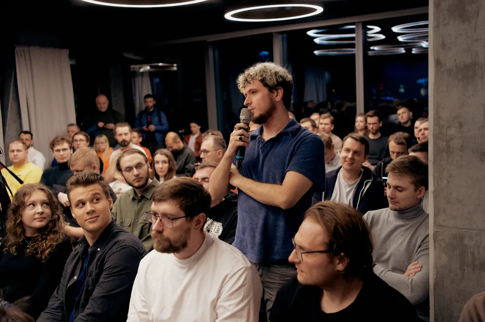 A guest asking a question with a microphone from the audience at Cloud focused meetup