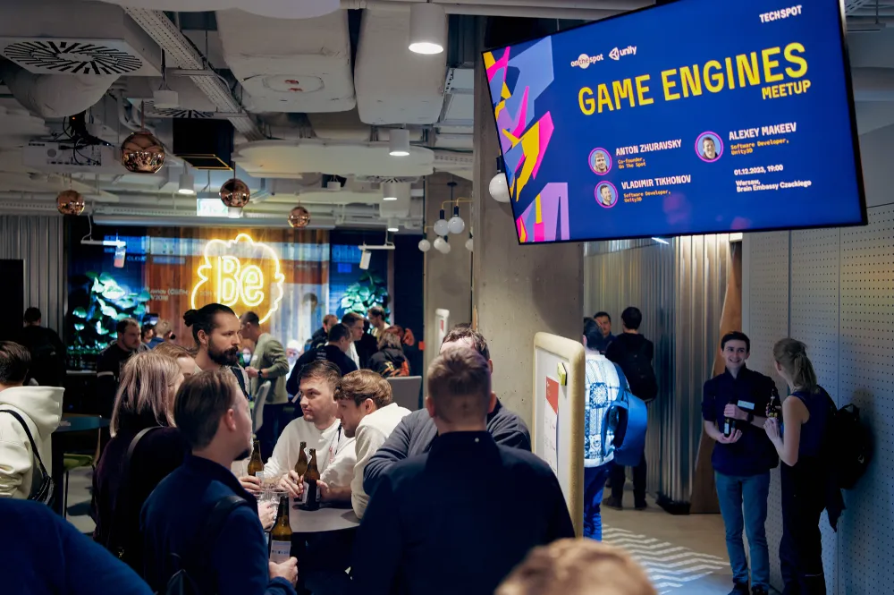 Guests in the venue of Inside game architecture, with the Game engines meetup screen on the wall
