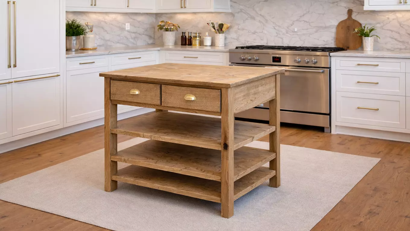 Rustic wooden kitchen island with two drawers and three shelves on a light rug in a modern white kitchen.