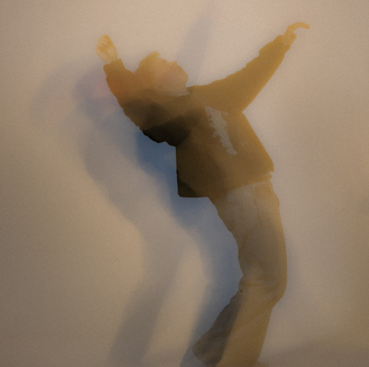 Person leaning backward with arms raised, wearing a dark jacket and light pants, casting multiple blurred shadows against a plain background.