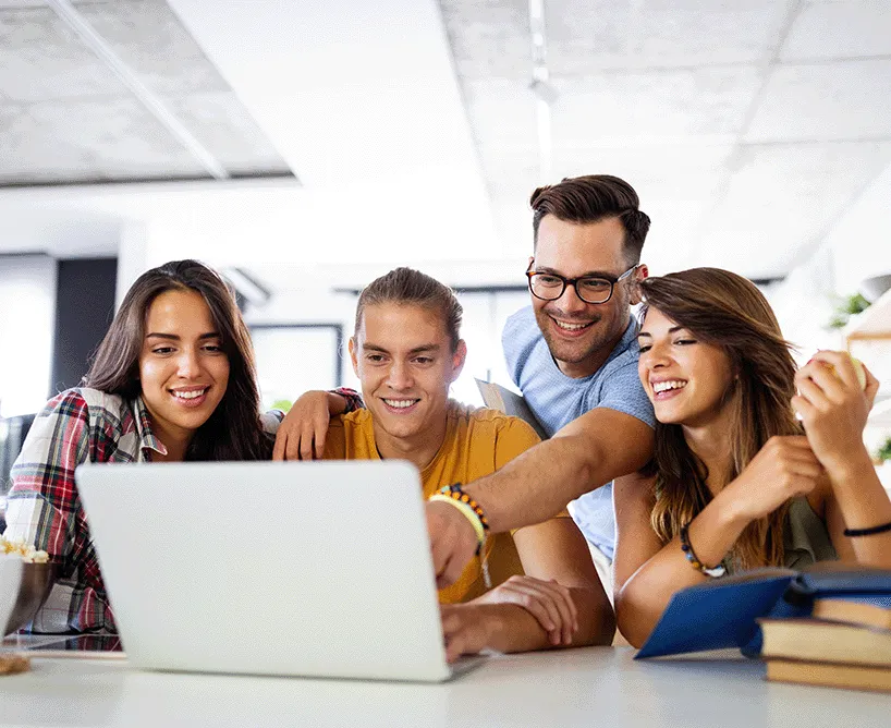 Vier Studierende um einen Laptop herum
