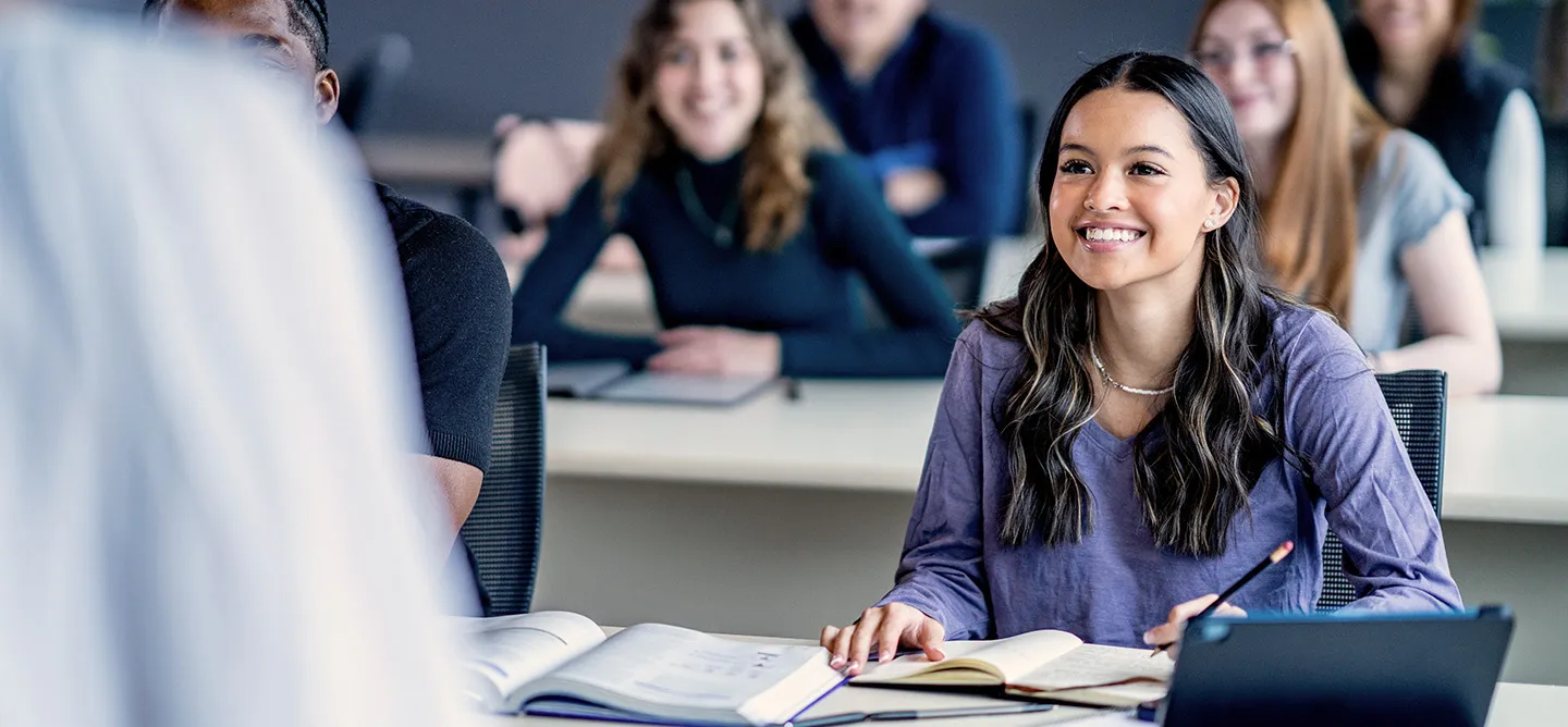 Studierende in einer Vorlesung mit einer Studentin im Fokus
