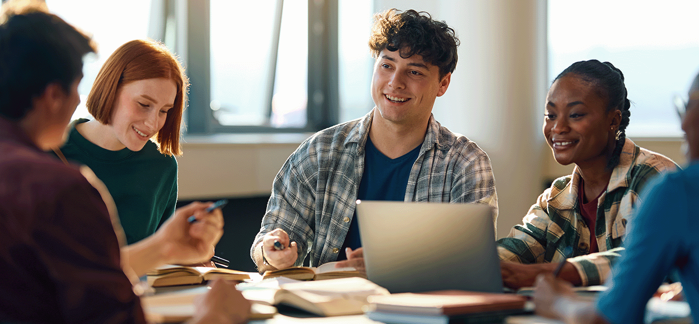 Studierende arbeiten gemeinsam an einem Projekt mit Laptop und Notizen