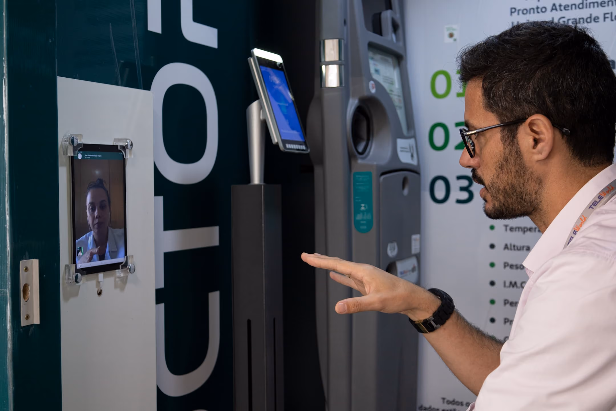 Foto de uma pessoa em frente ao tablet falazendo uma teleconsulta dentro de uma cabine