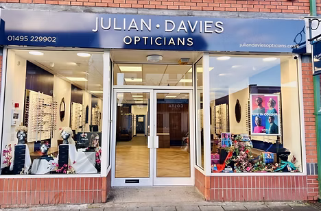 Storefront of Julian Davies Opticians with display windows and glasses