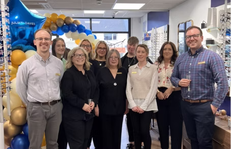 Team photo with balloons during office celebration or milestone event