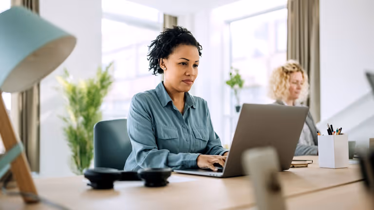 Two women work together in an office space