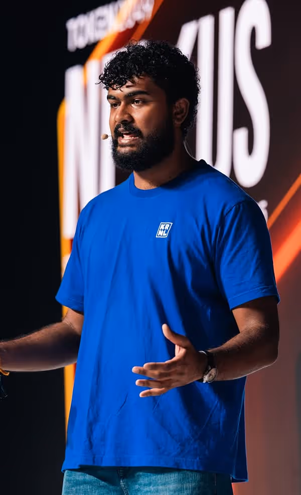 Speaker at TOKEN2049 in Singapore wearing blue shirt, gesturing during presentation