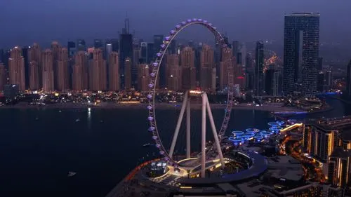 Dubai Ferris wheel at night with city skyline and marina in background