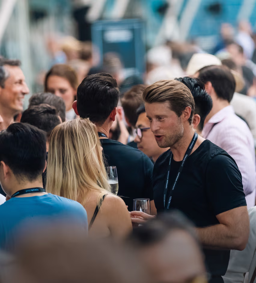 People networking and conversing at a social event, holding drinks.
