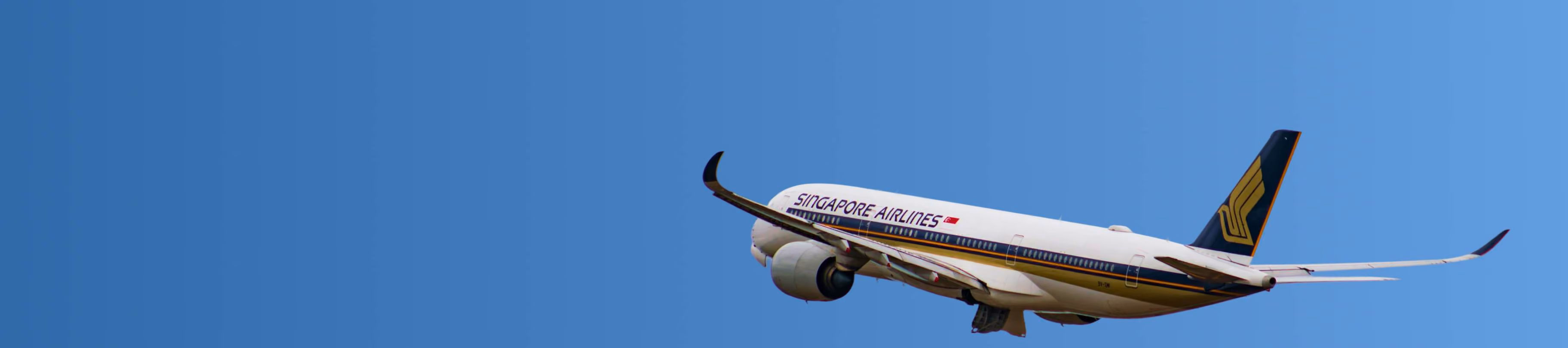 Singapore Airlines passenger airplane flying against a clear blue sky.