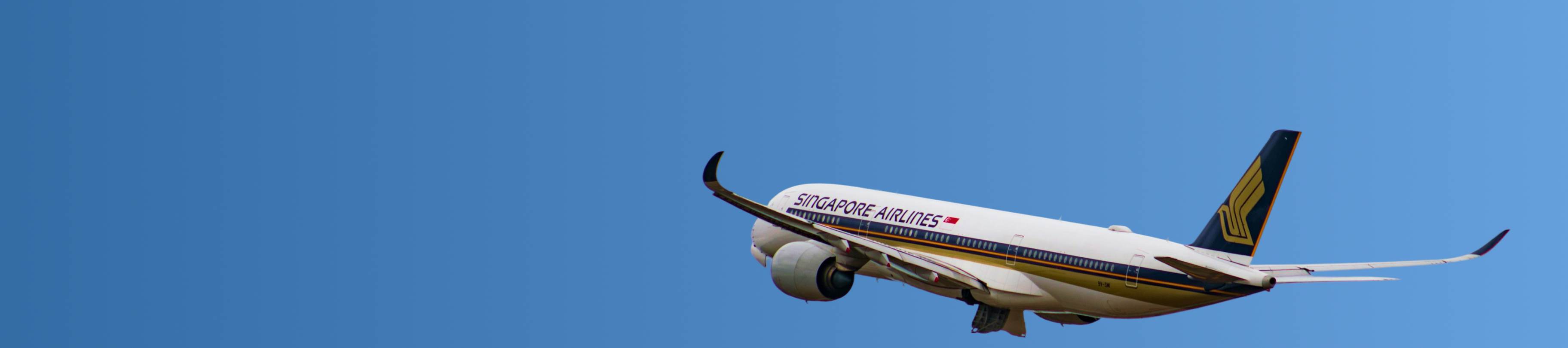 Singapore Airlines passenger airplane flying against a clear blue sky.