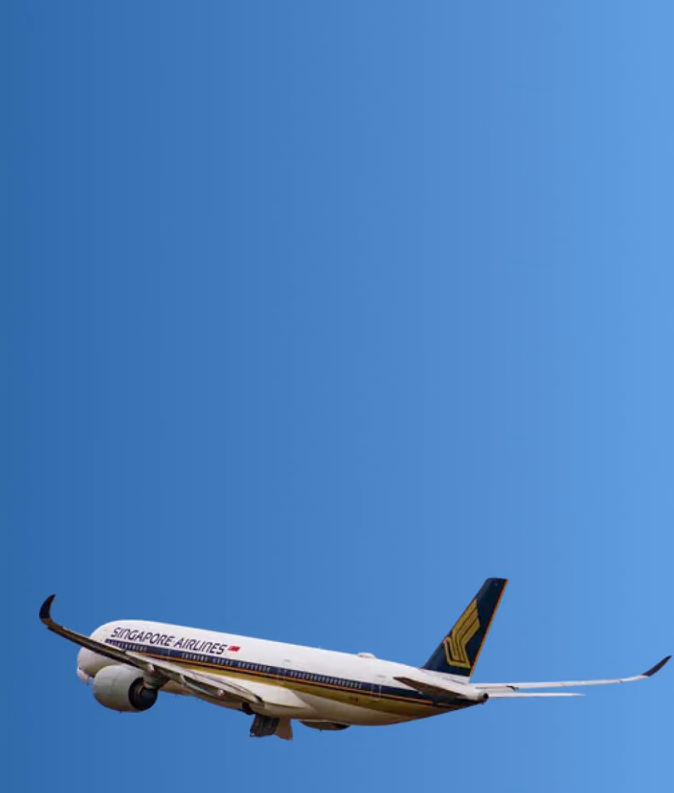 Singapore Airlines airplane flying in a clear blue sky.