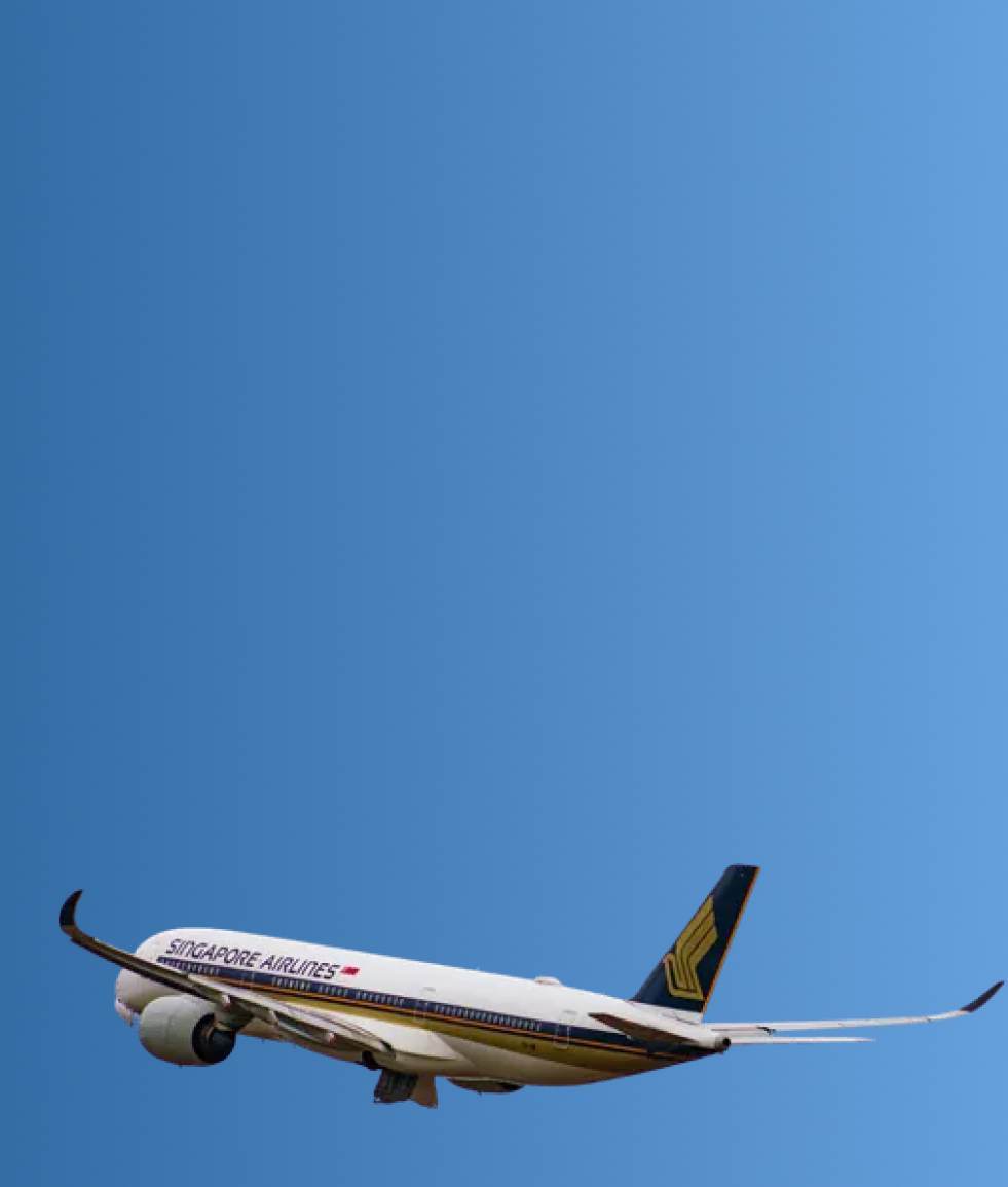 Singapore Airlines airplane flying in a clear blue sky.