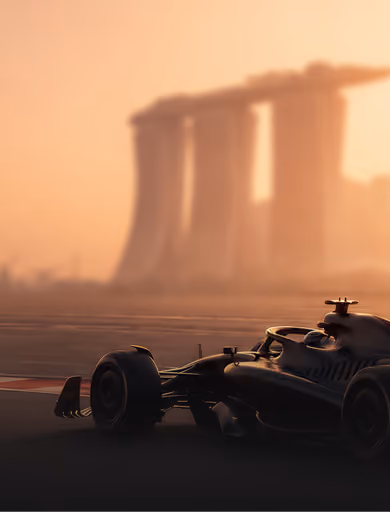 Silhouette of a Formula 1 race car on a track at sunset with the blurred Marina Bay Sands hotel in the background.