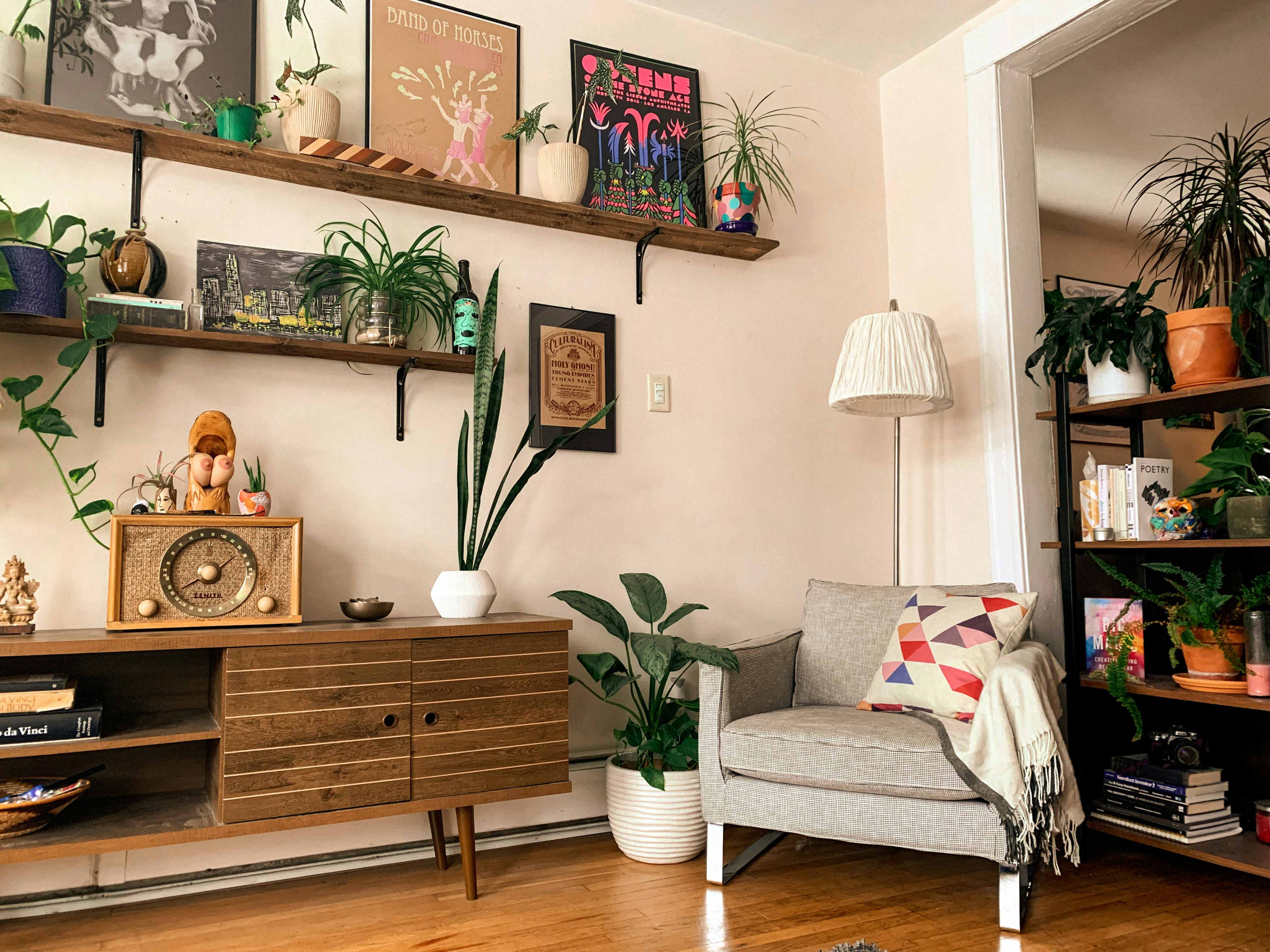 Lived-in Fort Wayne living room with open shelving, plants and hardwood floors