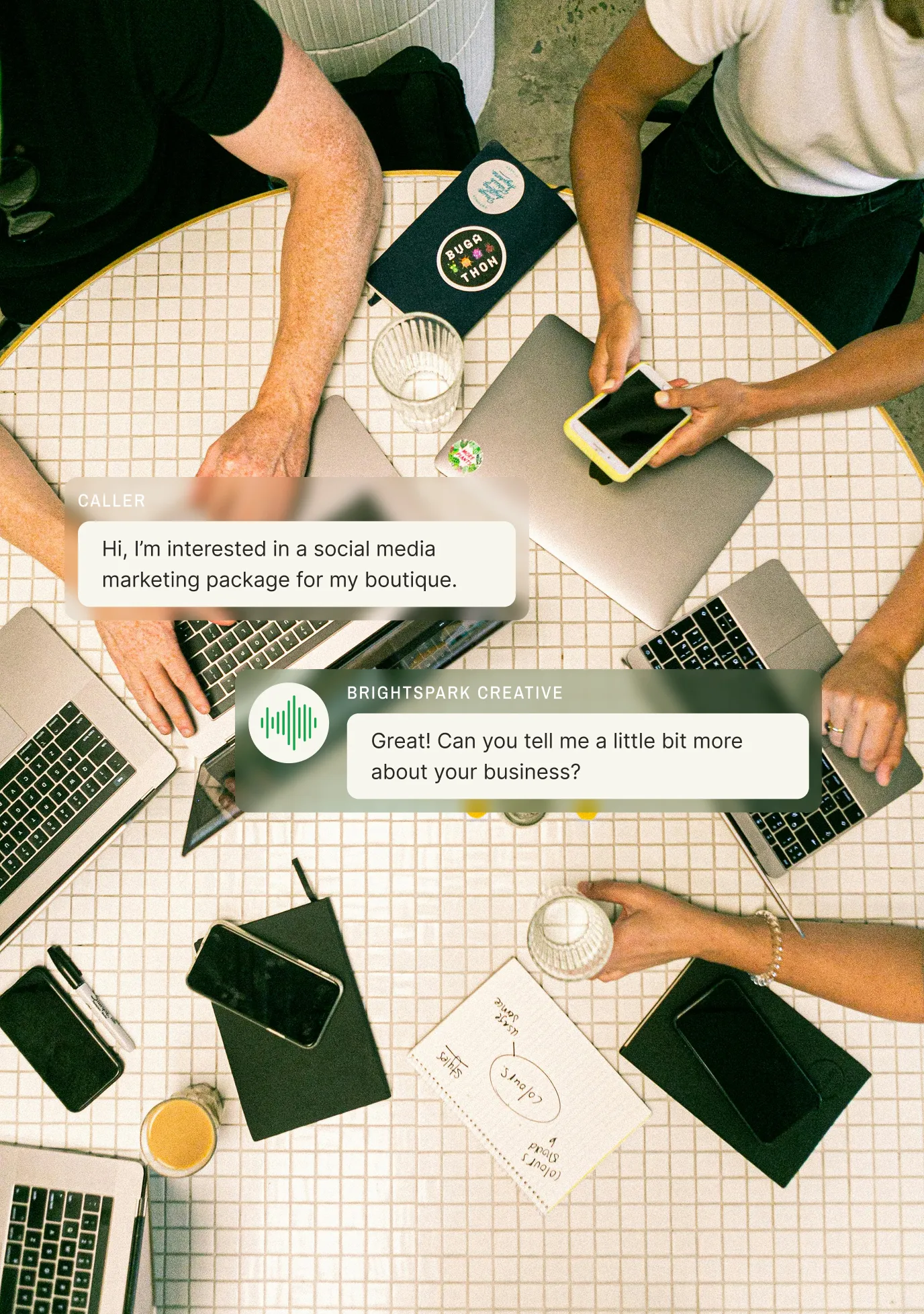 A marketing team collaborates around laptops as an answering service for social media marketing companies handles a call about a boutique's interest in marketing services.