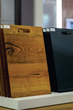 Holz- und schwarze Schneidebretter stehen auf einem weißen Podest.