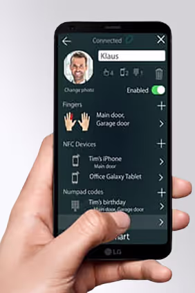Hand hält ein Smartphone mit einer Smart-Home-App, die Zugriffsrechte für Türen und NFC-Geräte anzeigt.