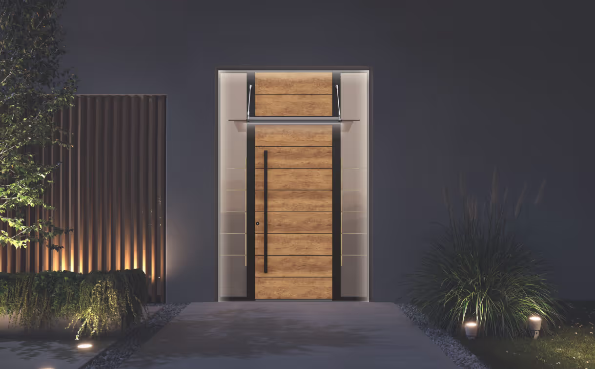 Moderne Holztür mit vertikalem schwarzen Griff, beleuchtet in einem dunklen Hauseingang mit Pflanzen rechts und links.