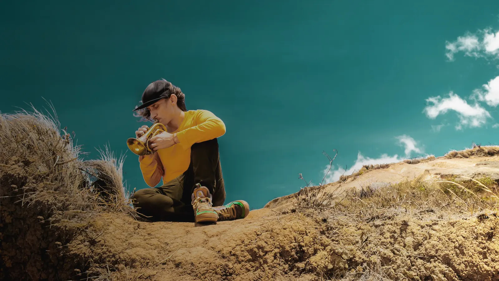 Der Musikkünstler Biomigrant spielt eine kleine Trompete.