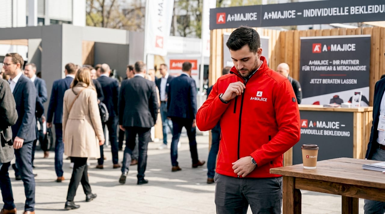 Jemand richtet an einer Eventjacke mit Logo die Ärmel zurecht.