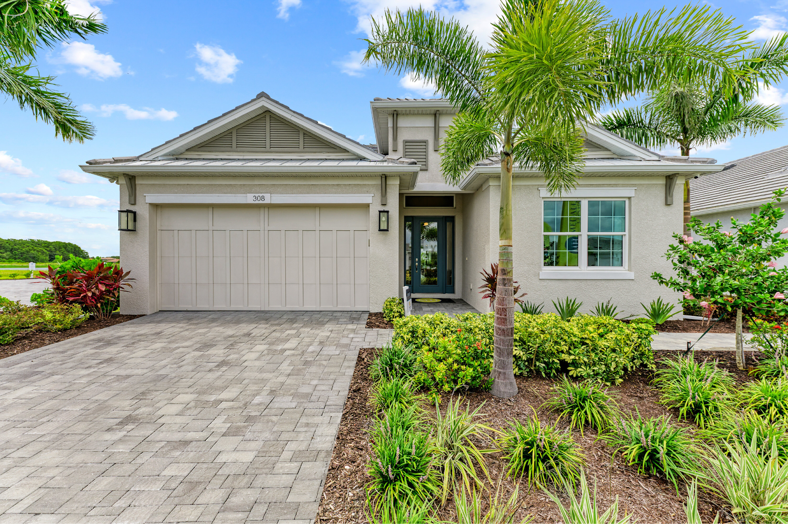 A paver driveway leads up to the garage of a home listed by Medallion Home in Florida.