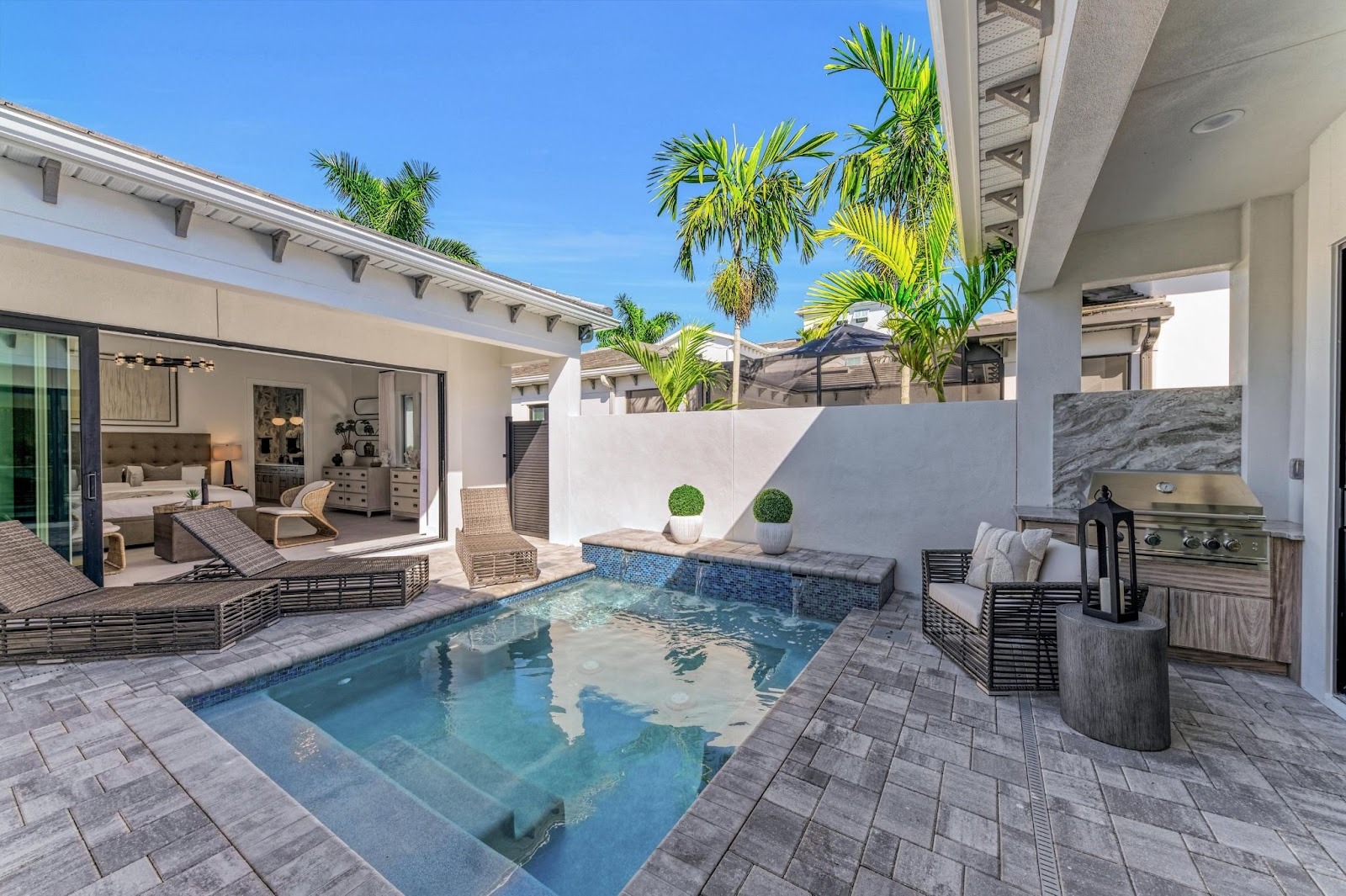 Medallion Home model home backyard exterior featuring a spool and built-in outdoor kitchen