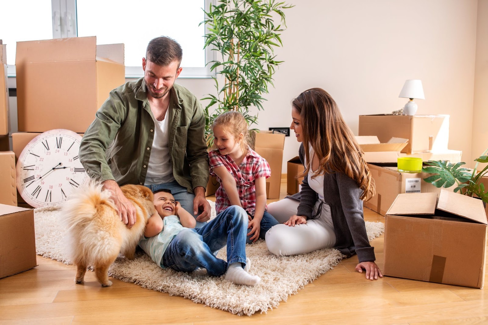 Happy family sitting in a living room surrounded by moving boxes