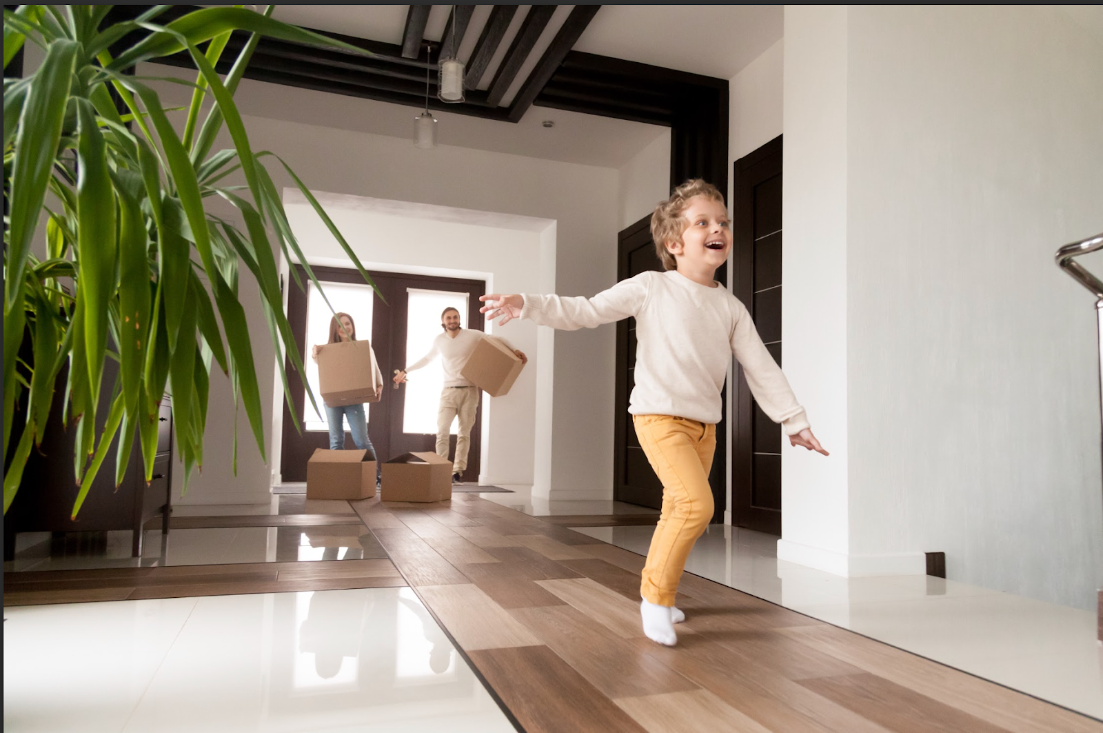 Happy couple with young son arriving in new home.