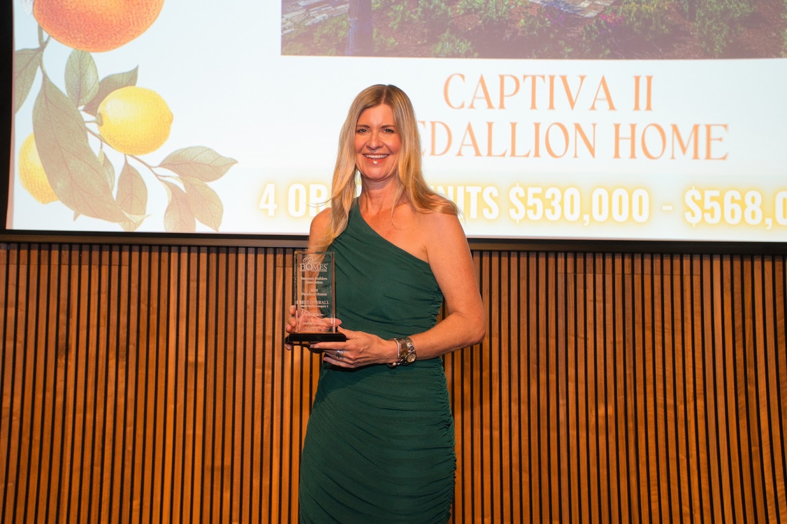 Medallion Home team member on stage accepting a Parade of Homes award