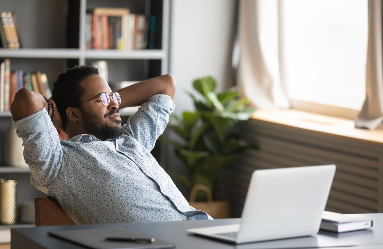 African American man relaxing in office chair in his home office