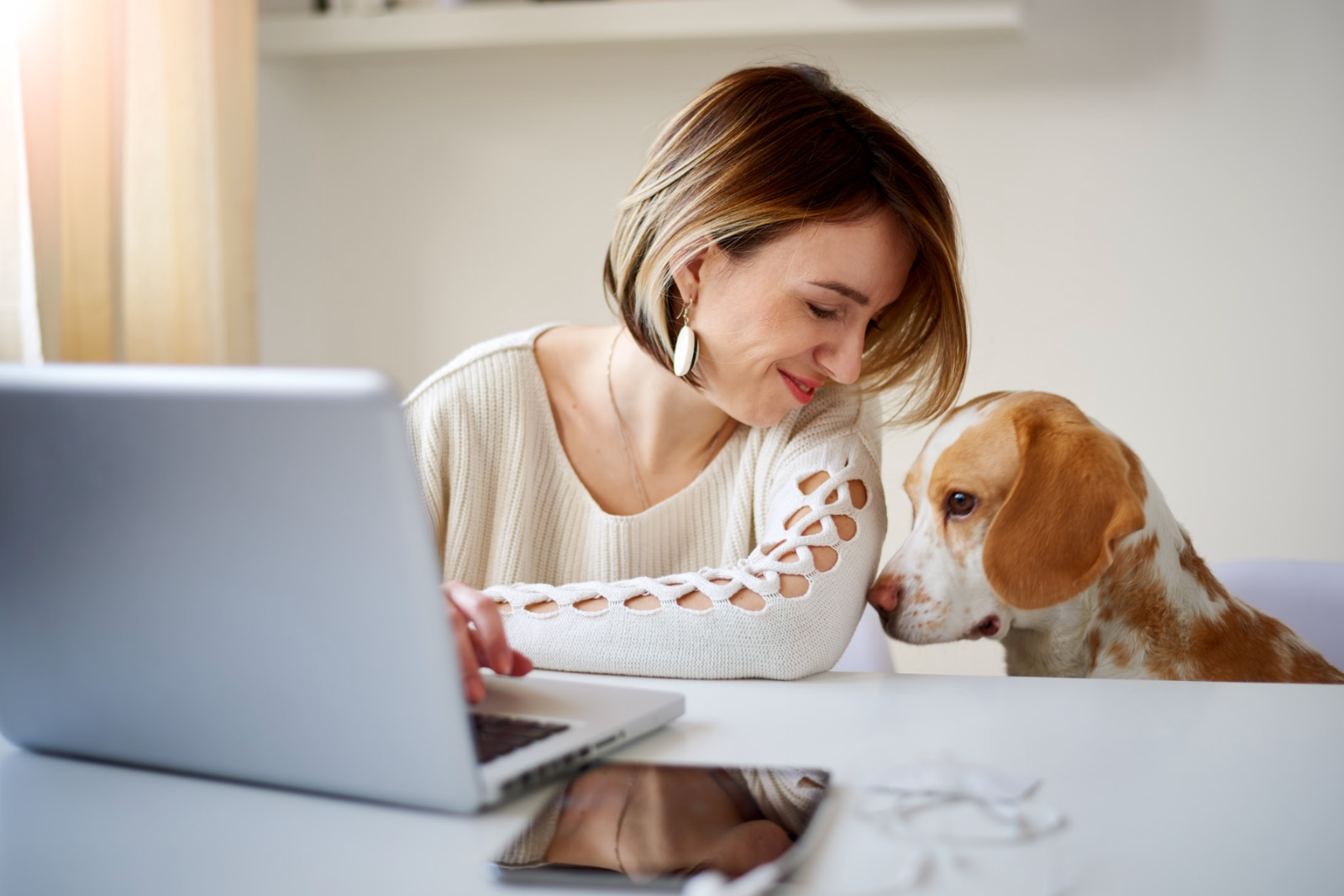 Woman working from her home office with her dog.