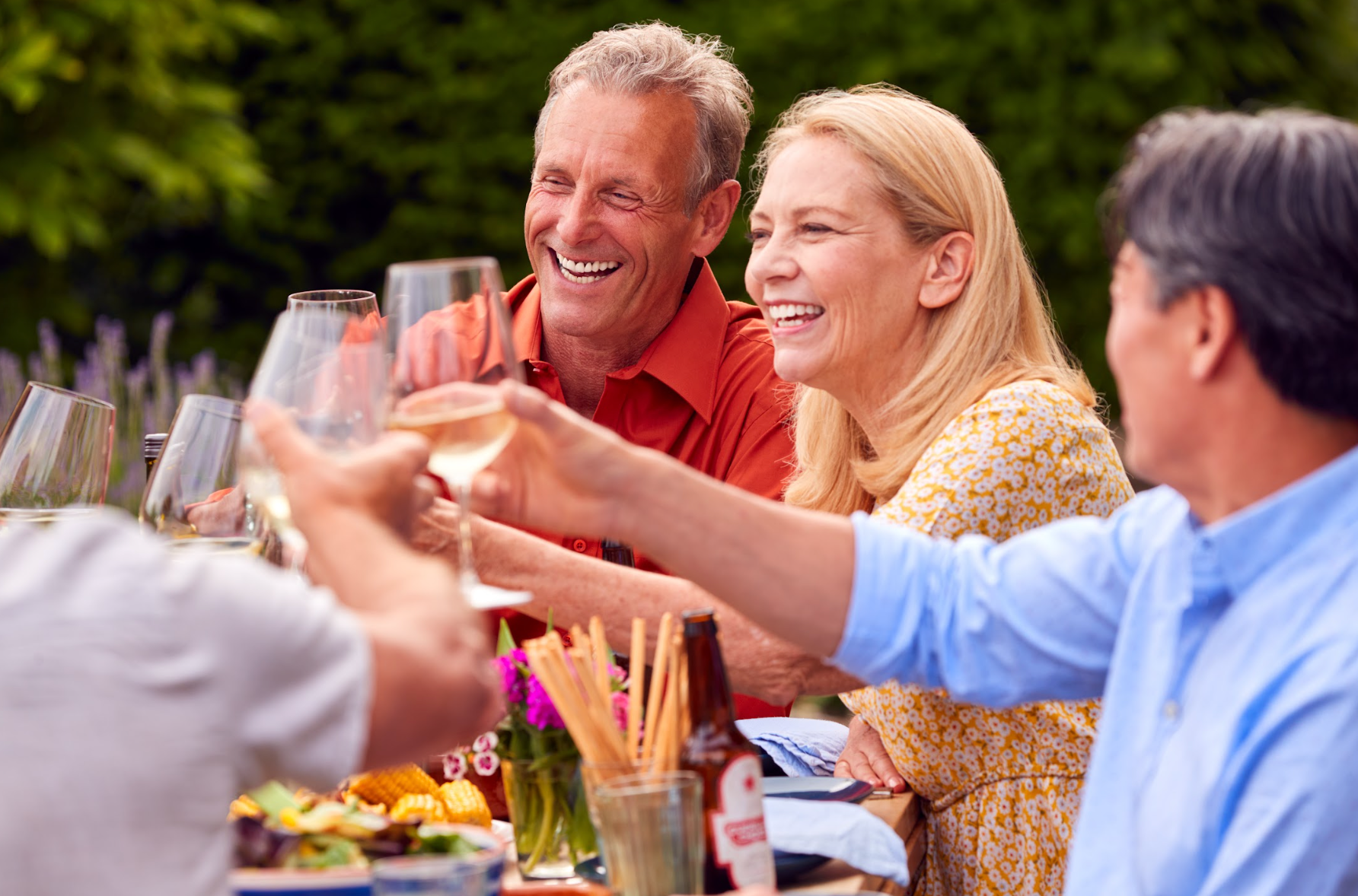 Group of mature friends making a toast outside. 