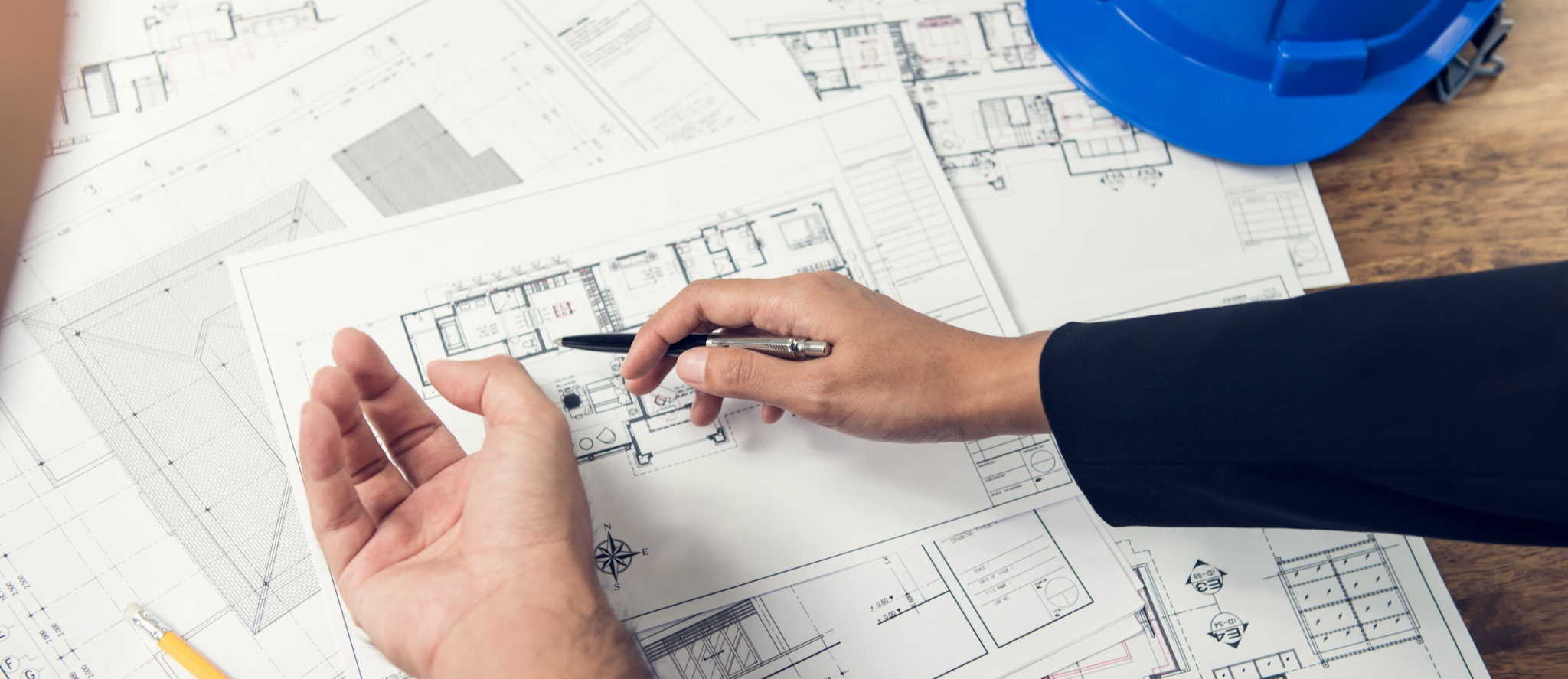 Architect team discussing floor plan layout at the table.