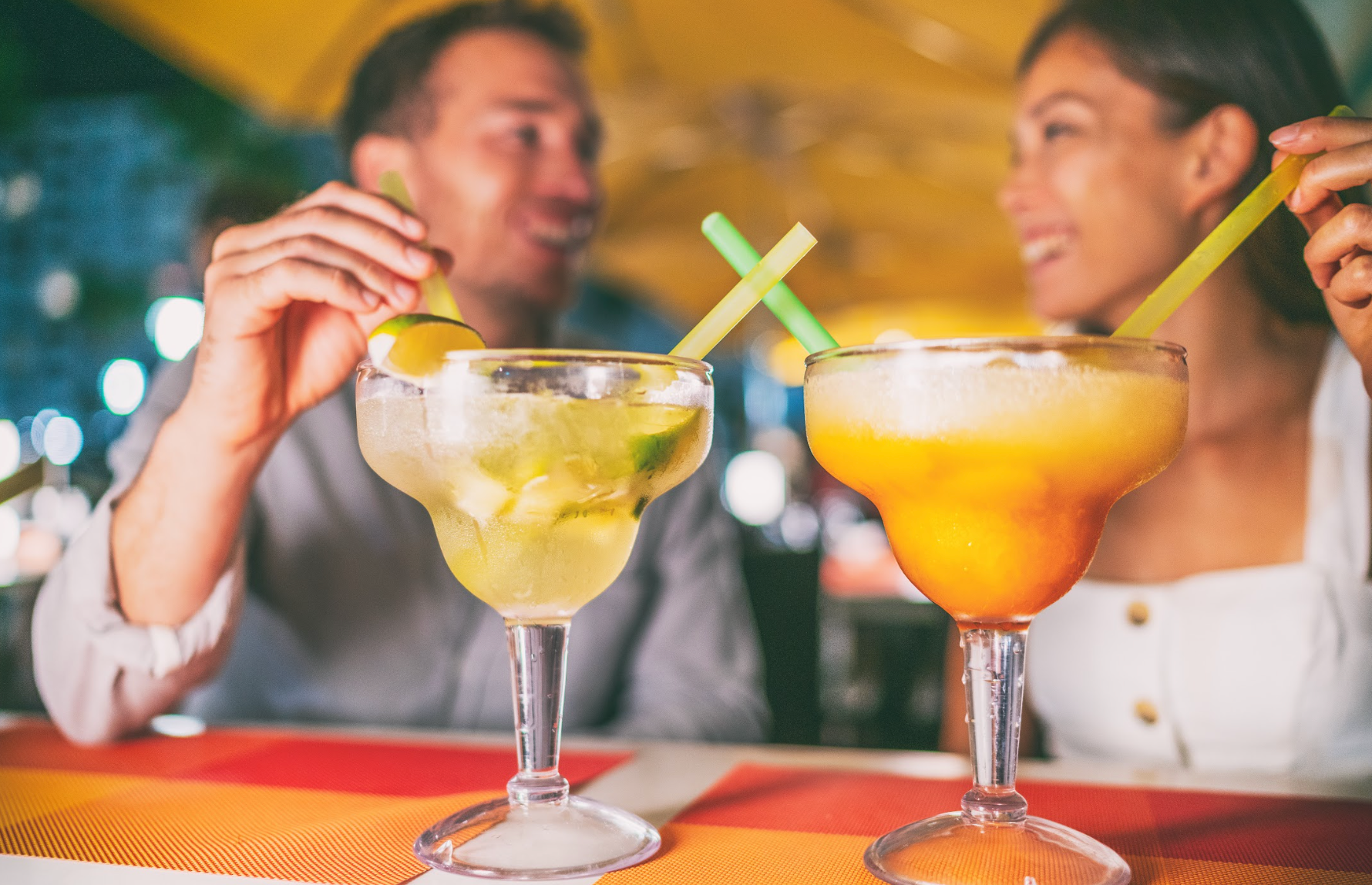 ouple enjoying fun cocktails at a bar in the evening