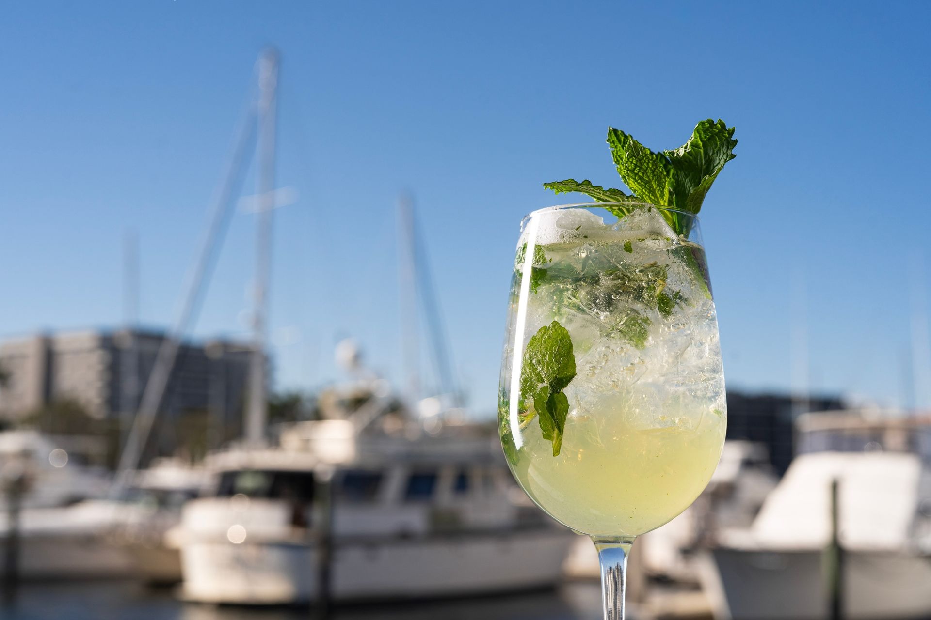 Refreshing cocktail with boats on the pier in the background