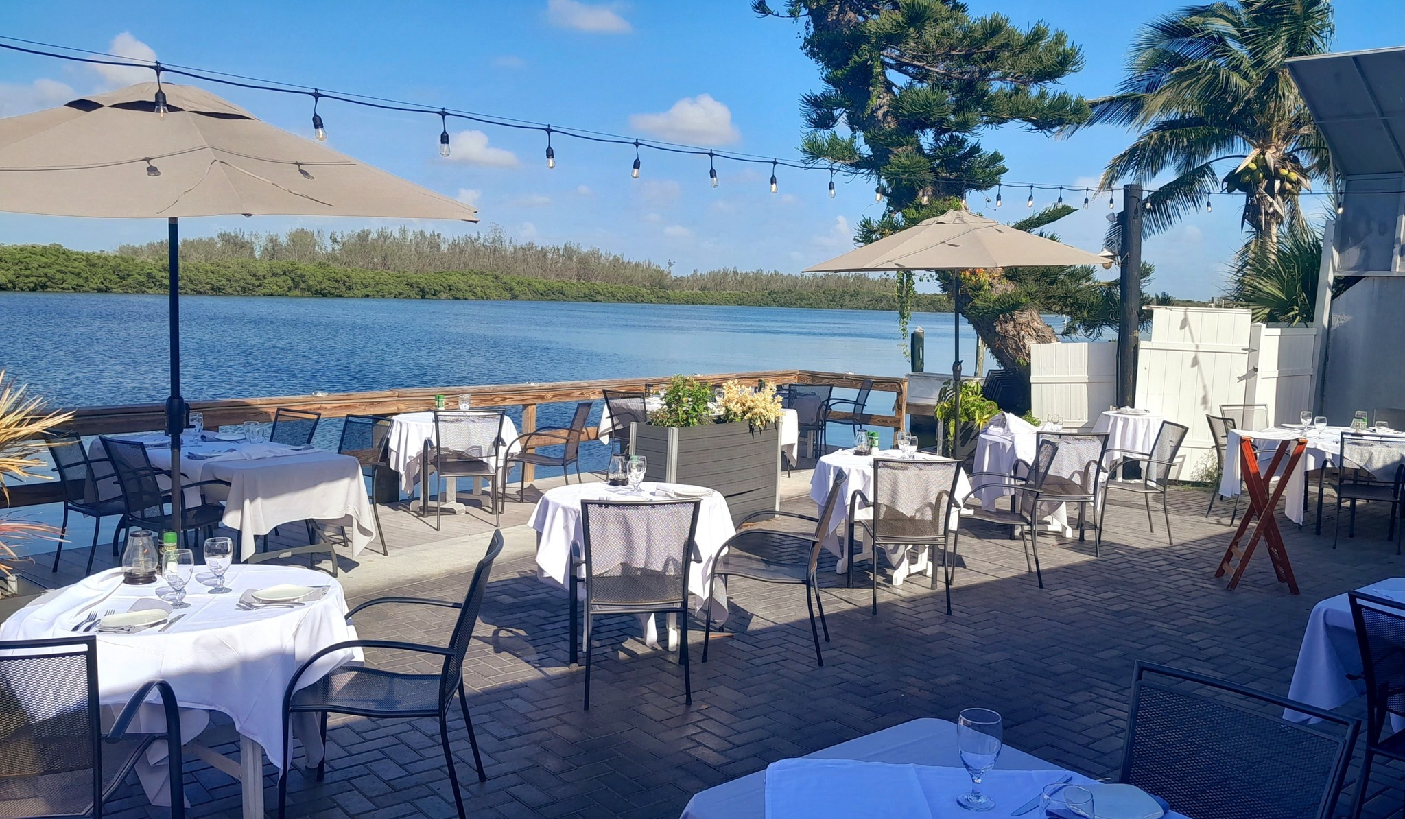 Outdoor dining tables at Ophelia’s on the Bay on a sunny day CAPTION: Photo credit: Ophelia’s on the Bay