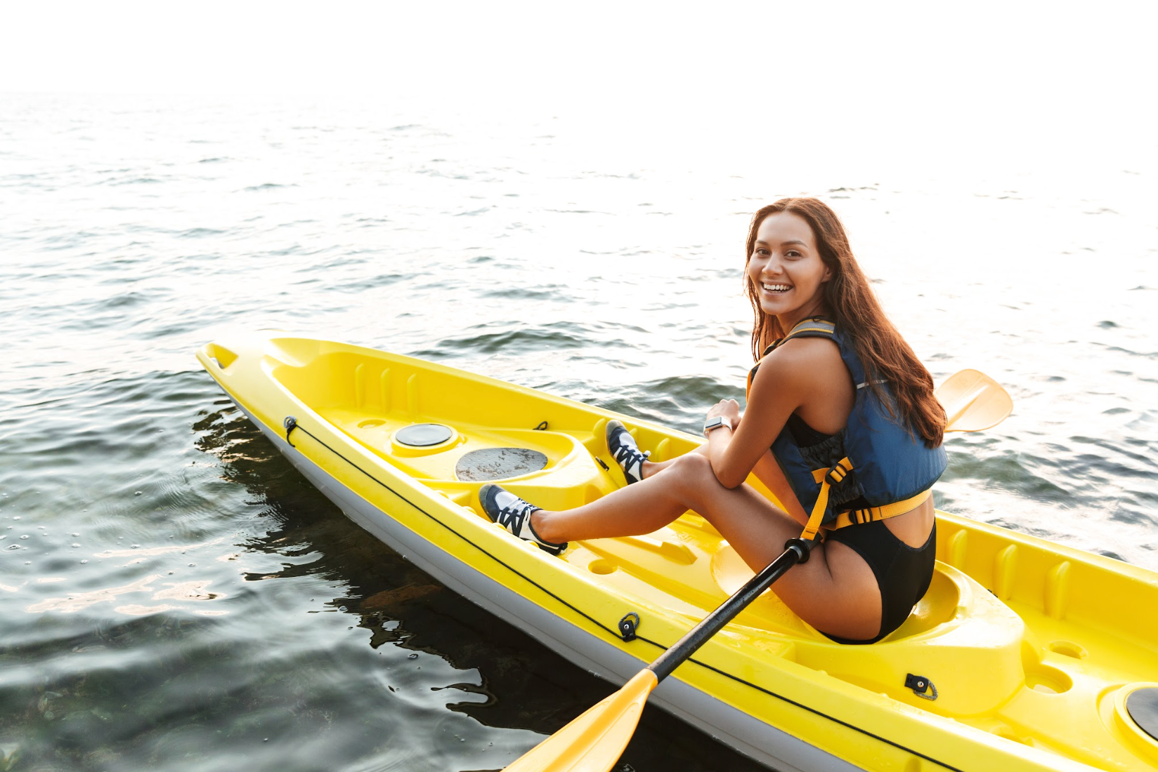 Happy woman kayaking on the water