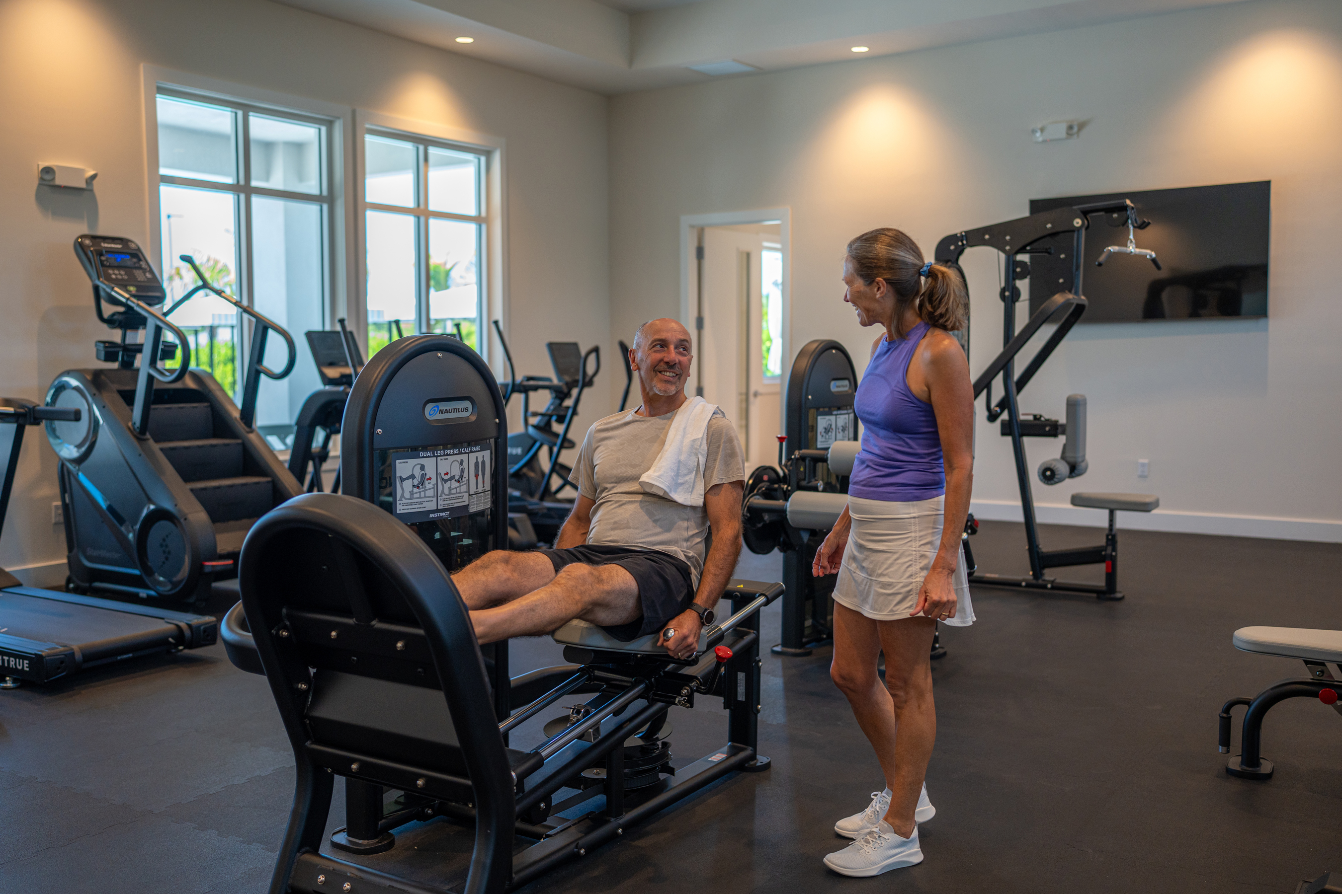 Two people working out in the fitness center at Watercolor Place by Medallion Home